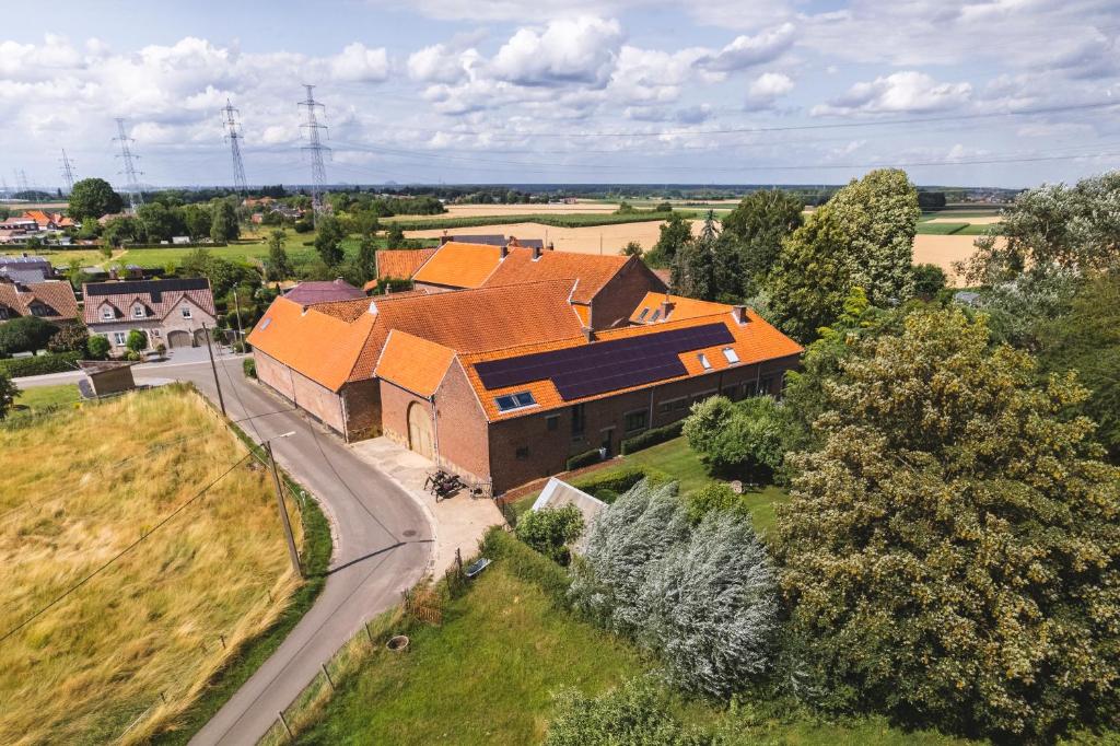 比尔曾Vakantiewoning & Fietslogies V E L O, Tussen Hasselt en Maastricht的享有大型砖砌建筑的顶部景色,设有橙色屋顶