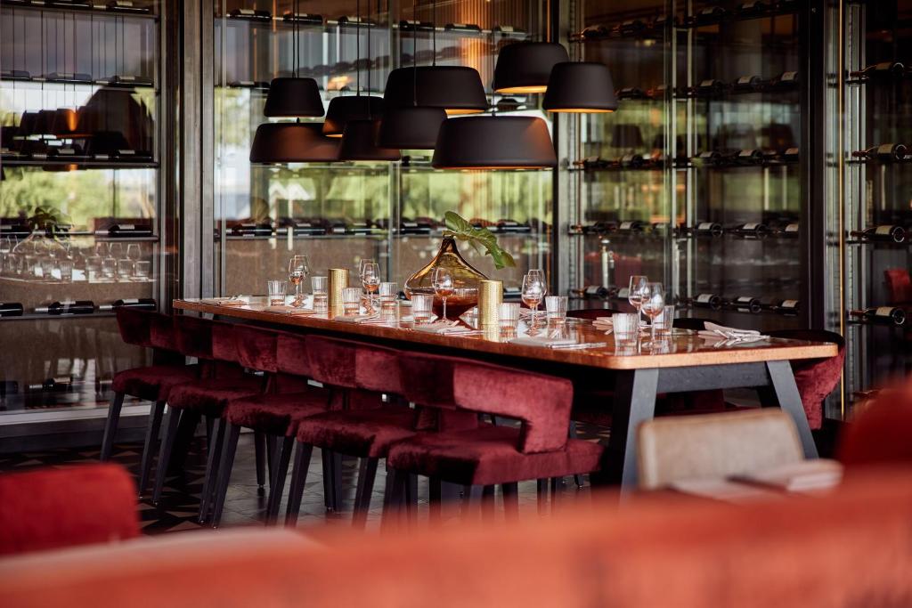 费嫩达尔费嫩达尔范德瓦尔克酒店的餐厅里一张长桌子和红色椅子