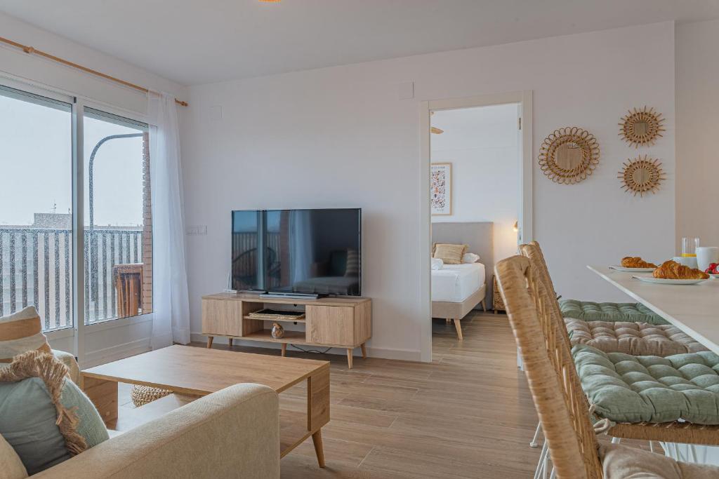 阿勒纳勒斯德尔索尔Myflats Premium Beach Front的带沙发的客厅和带电视的客厅。