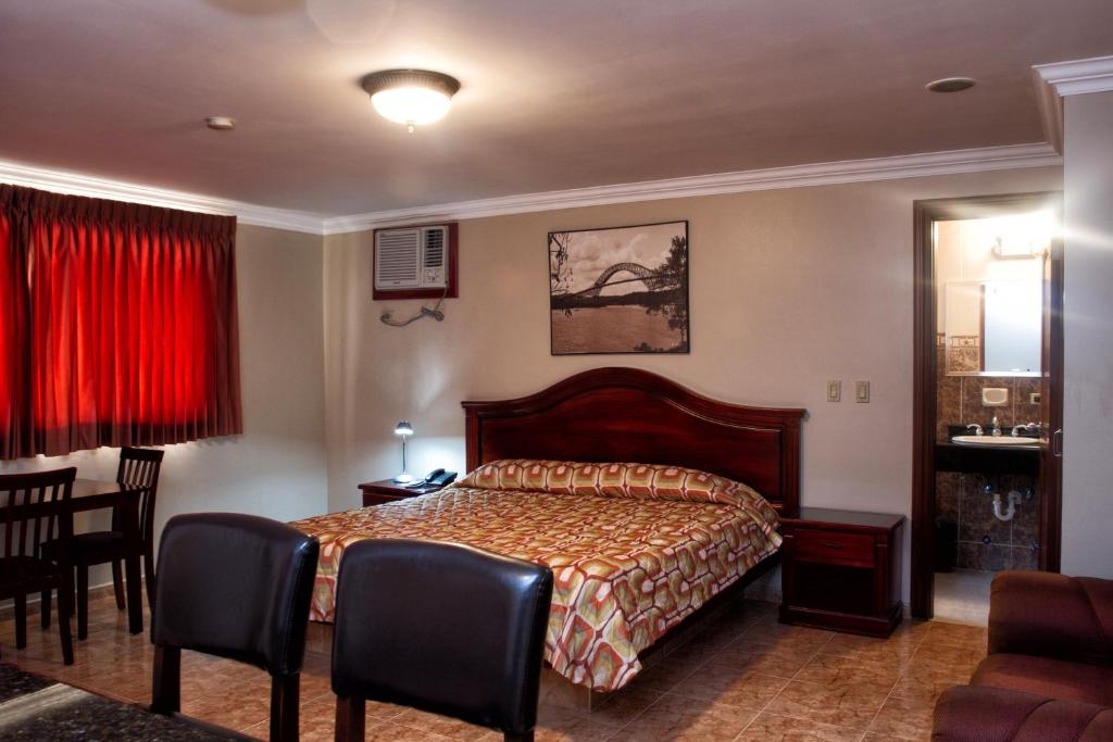 巴拿马城米兰巴拿马酒店的卧室配有一张床和一张桌子及椅子