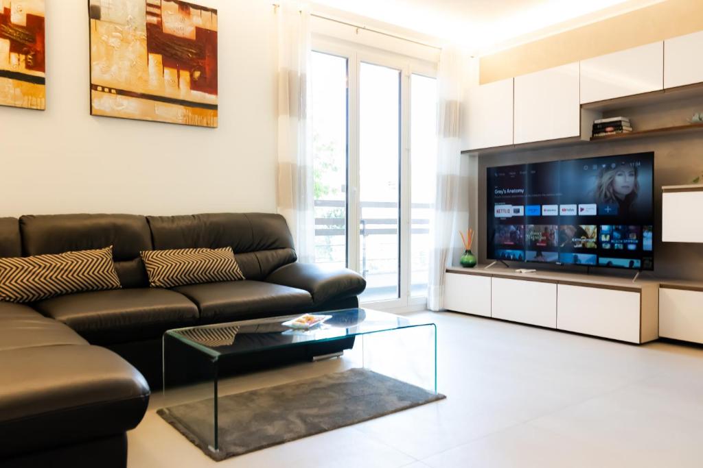 卢加诺Wonderful Apartament, Near The Lake的客厅配有真皮沙发和电视