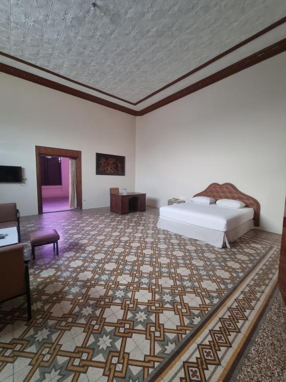 JomblangHotel Candi Baru的一间卧室配有一张床,地板铺有地毯