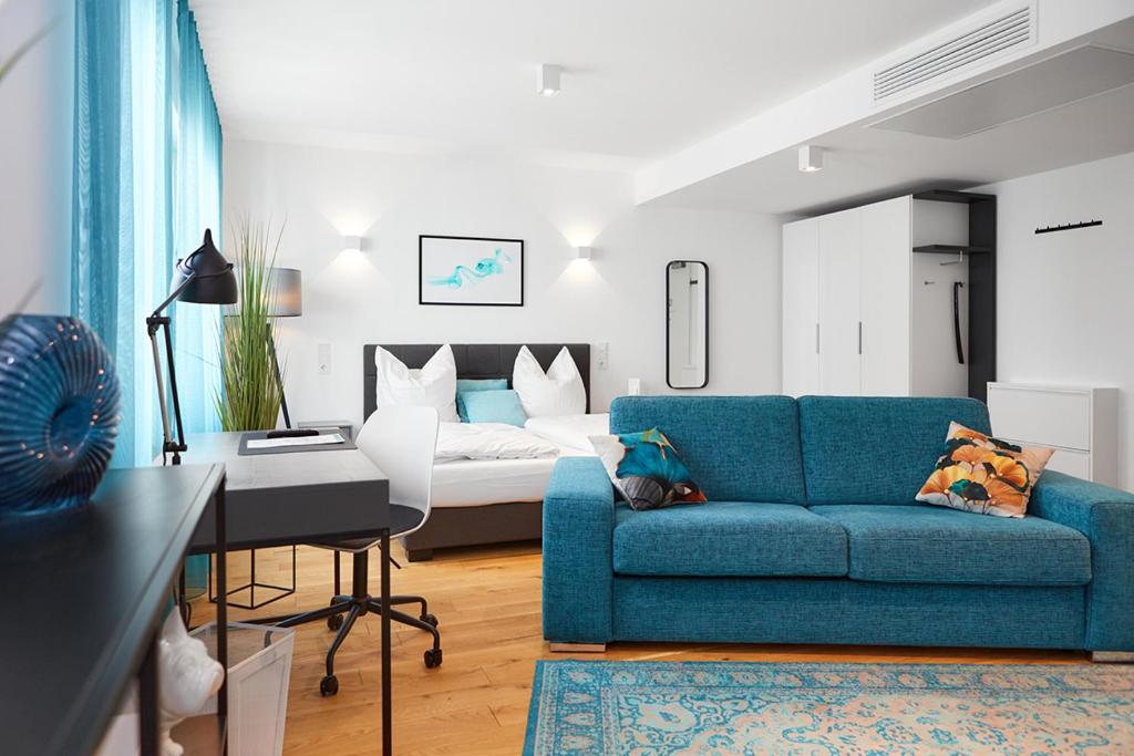 埃朗根SERVENTO Boardinghouse的客厅配有蓝色的沙发和床。