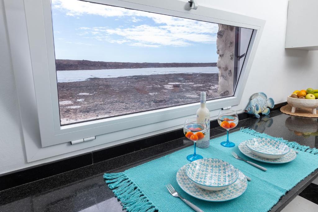 拉奥利瓦Vista Paraiso near the beach的窗前带两个盘子和酒杯的桌子