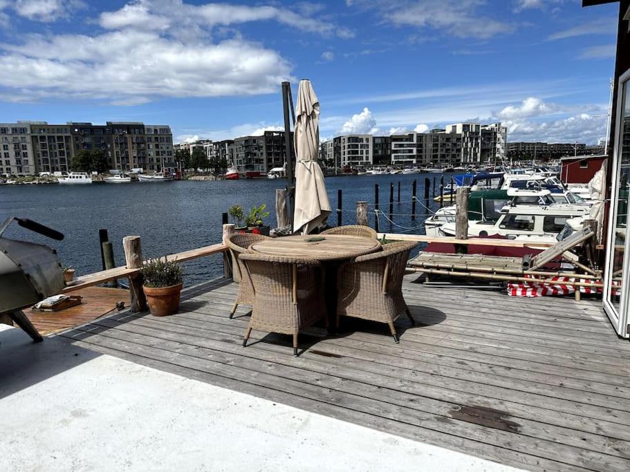 哥本哈根Unique boathouse.的木甲板配有桌子和遮阳伞