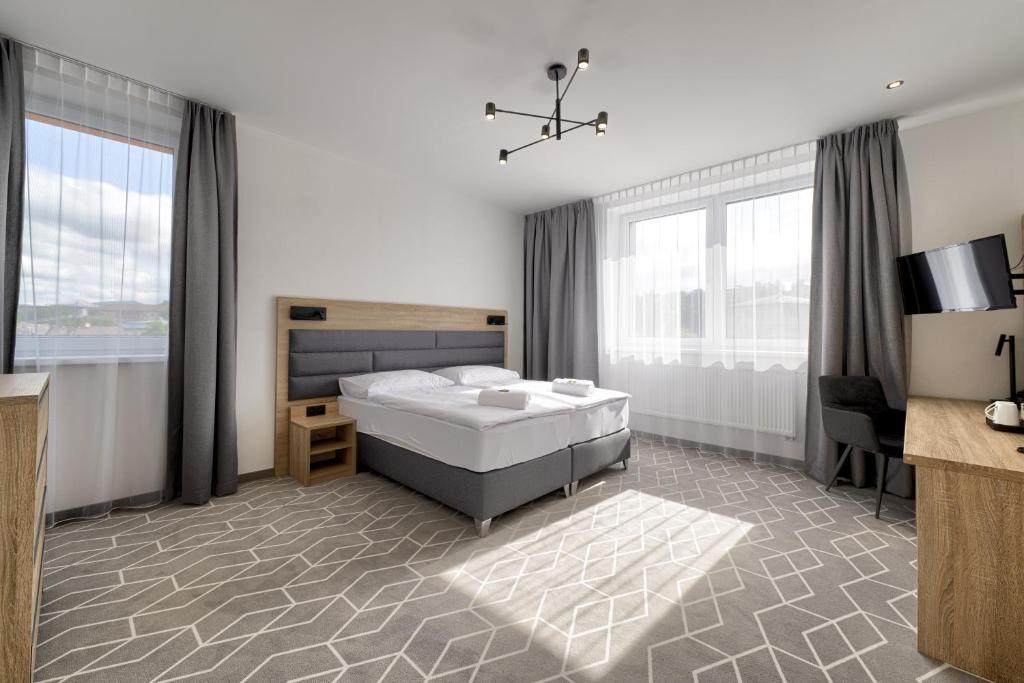 MedzilaborceTypton hotel&spa的卧室配有一张床、一张书桌和窗户。