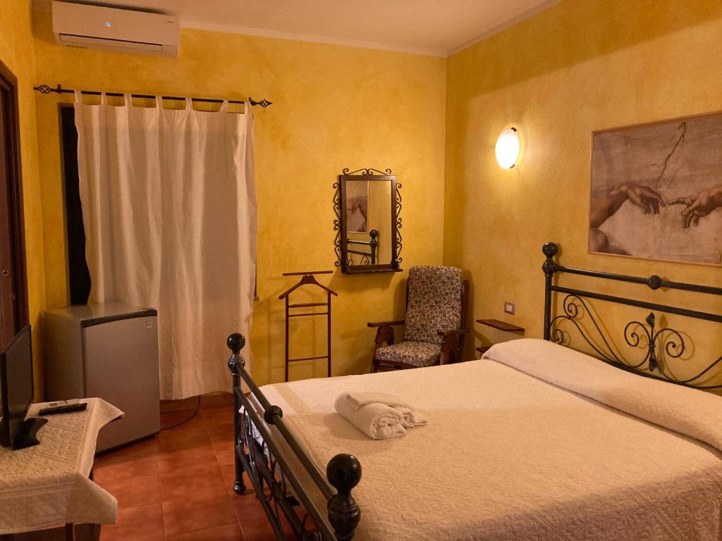 圣彼得罗镇Araxi的一间卧室配有一张床、一把椅子和镜子