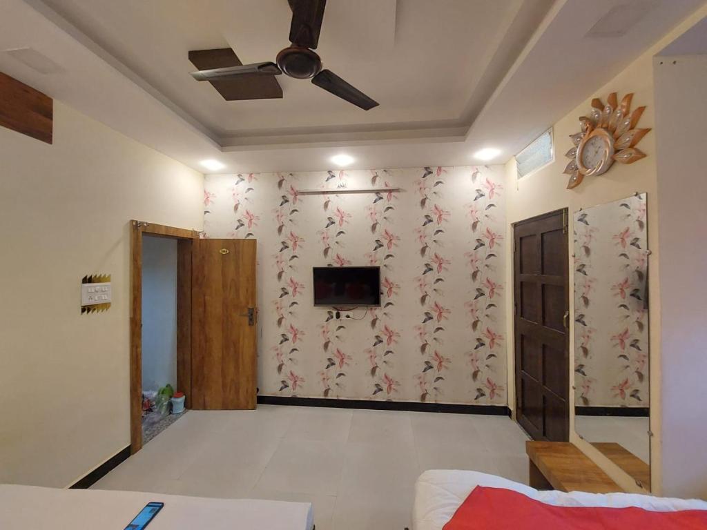 乌贾因Parvati home stay的客厅配有吊扇和电视。