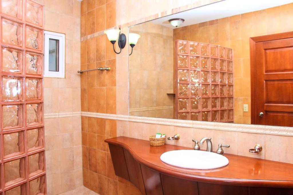 罗阿坦Hotel West Bay Colonial的一间带水槽和镜子的浴室