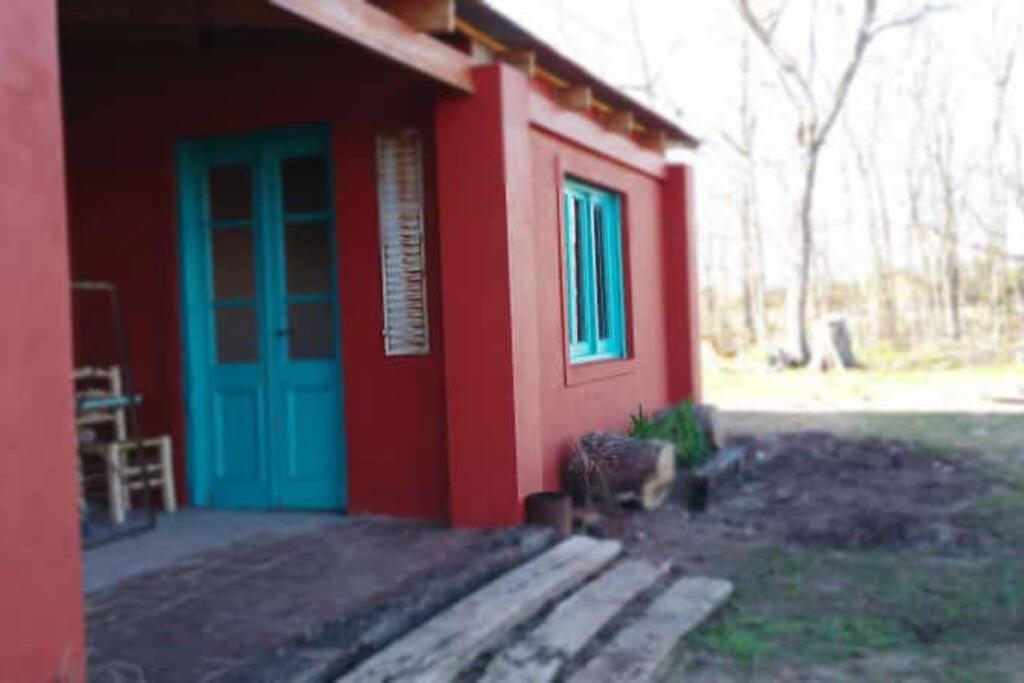 默西迪丝Casa de campo的蓝色的红色房子,有蓝色的门