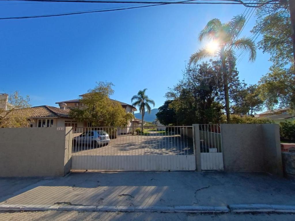 弗洛里亚诺波利斯Residencial Caramujo的白色围栏和棕榈树的房子