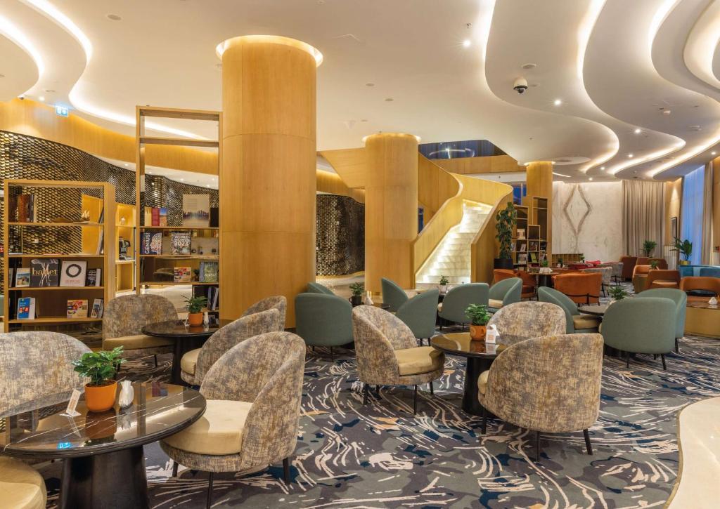 多哈Embassy Suites By Hilton Doha Old Town的大堂,设有桌椅