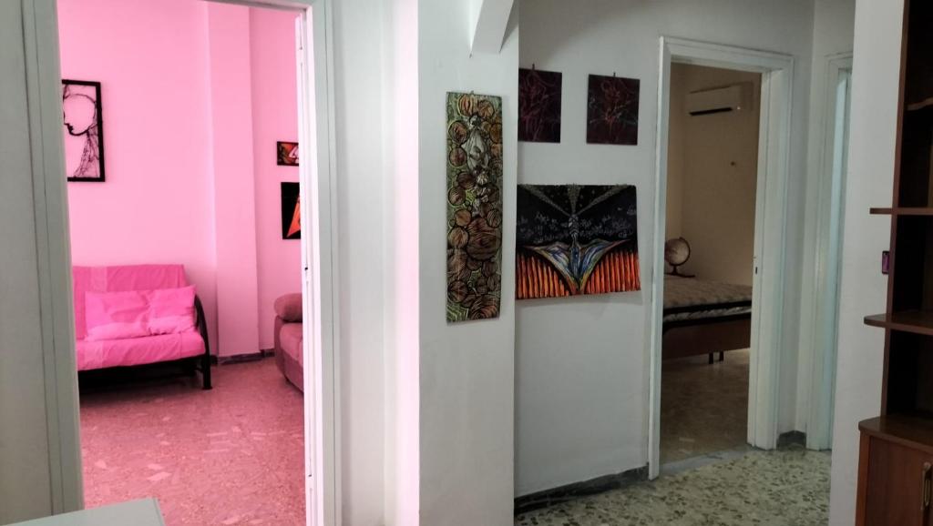 布林迪西Casa Vacanza Casale的粉红色的客房配有粉红色的沙发和镜子