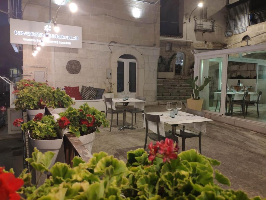 Minervino MurgeTaverna Garibaldi Casa Lucia的一间设有桌椅的餐厅,种植了植物