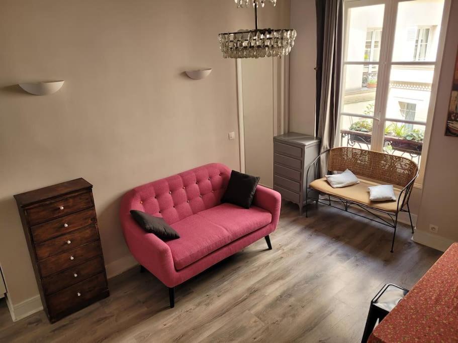 巴黎Appartement entier - Paris 12的客厅配有粉红色的沙发和梳妆台