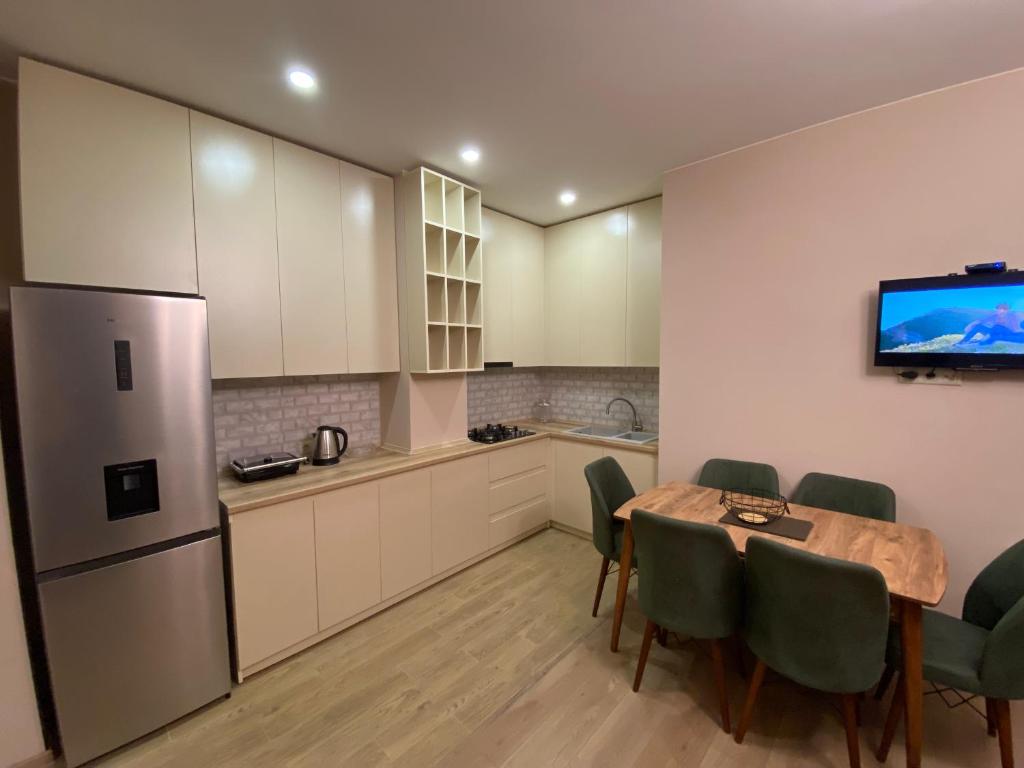 库塔伊西Dani Apartment的厨房配有桌椅和冰箱。