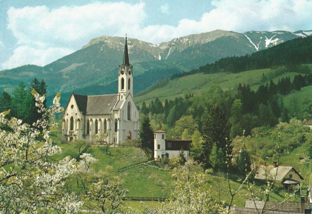 Gemütliche Ferienwohnung - Prein an der Rax的一座教堂,位于山丘上,背景是山丘