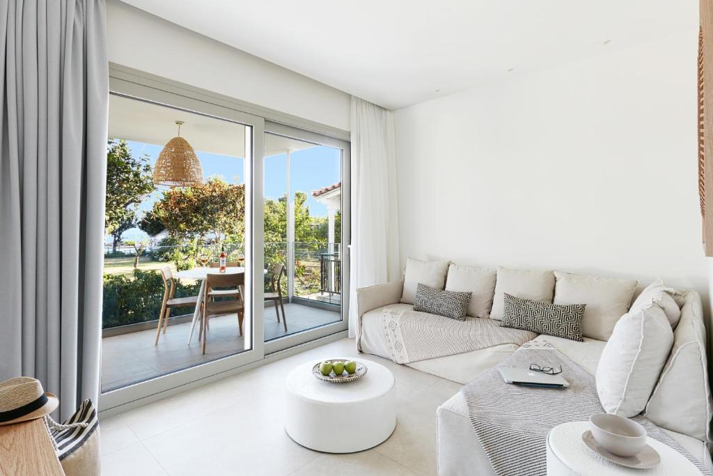 斯基亚索斯镇Skiathos Ammos Luxury Apartments的白色的客厅配有沙发和桌子