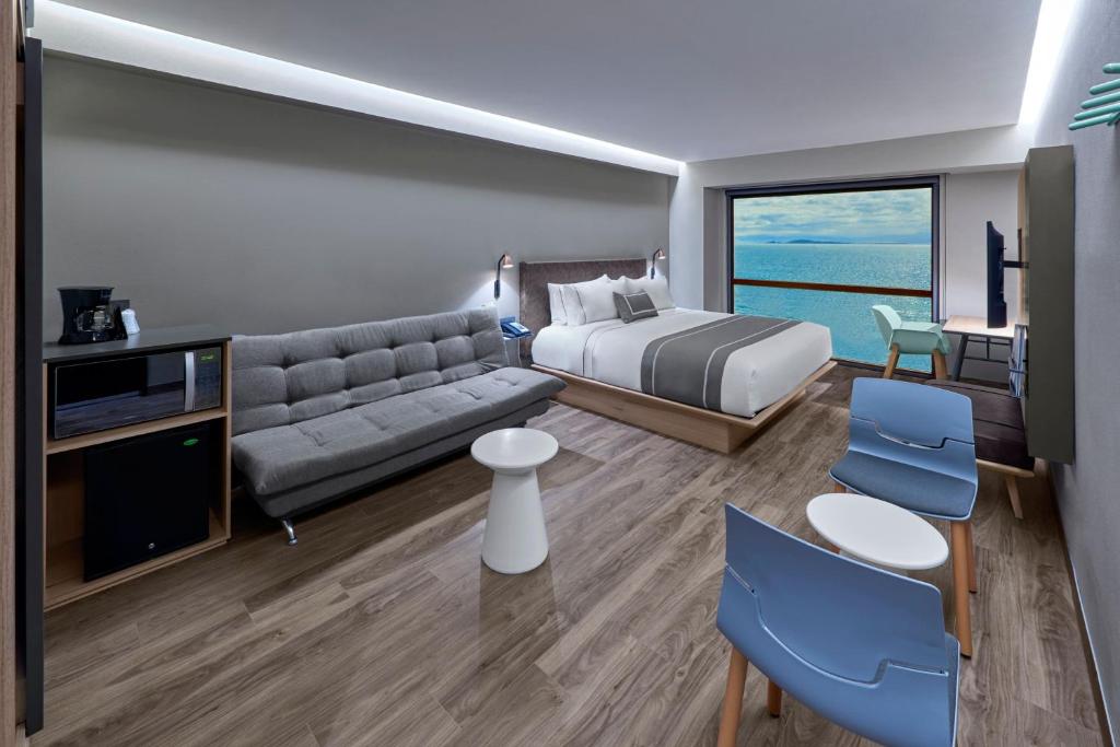 恩塞纳达港City Express Plus by Marriott Ensenada的酒店客房,配有床和沙发