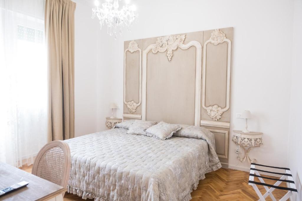 维亚雷焦Althea的白色卧室配有一张床和一个吊灯