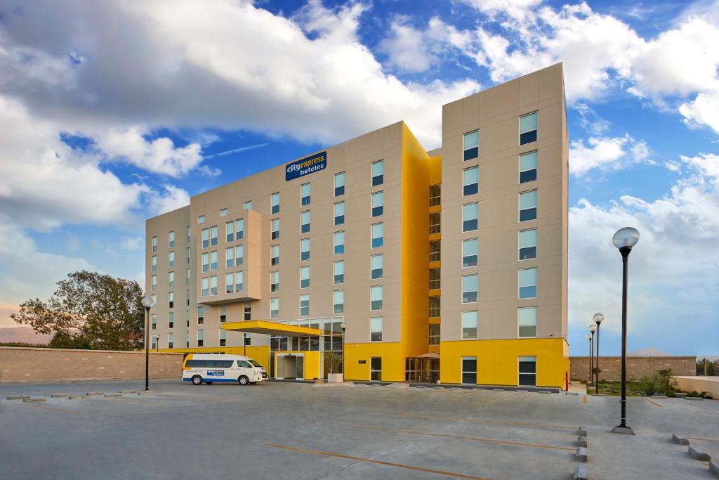 恩塞纳达港City Express by Marriott Ensenada的前面有停车场的酒店