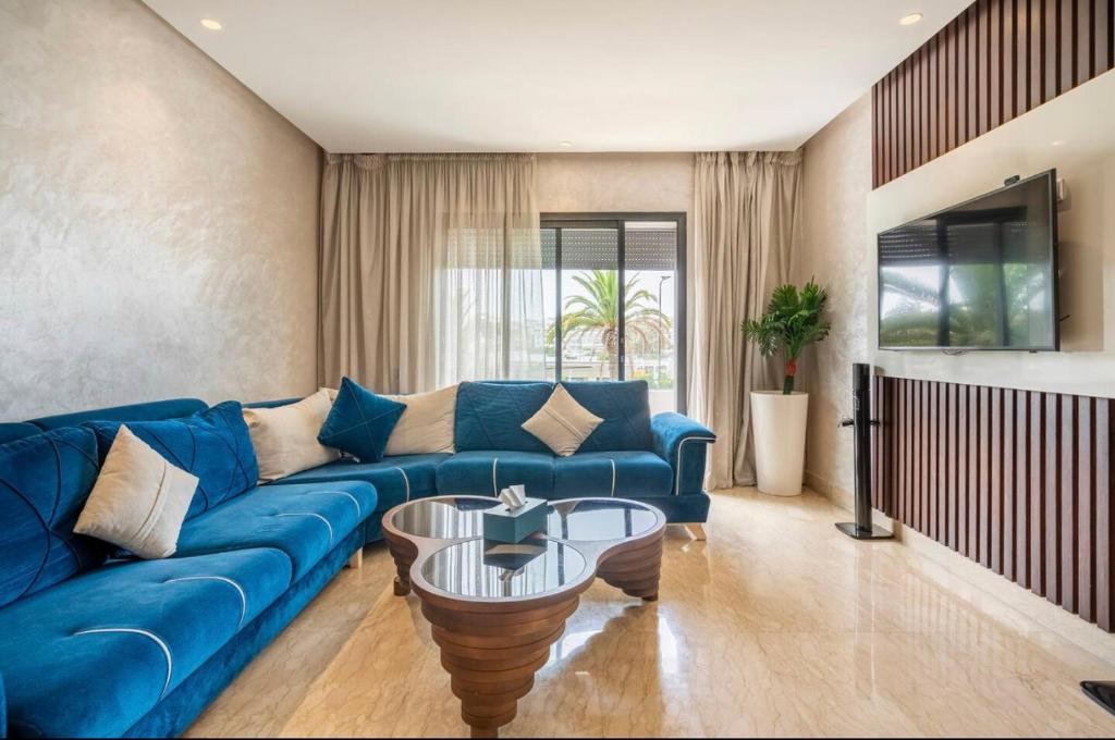 卡萨布兰卡Incantevole Luxury apprt nel cuore di Casablanca的客厅配有蓝色的沙发和桌子