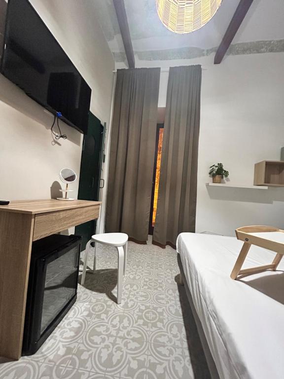 塔兰托Casa la cava的一间卧室配有一张床、一台电视和一把椅子