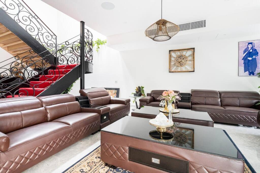 奎斯特邦多拉Luxurious house in peaceful natural surroundings的客厅配有皮革家具和楼梯