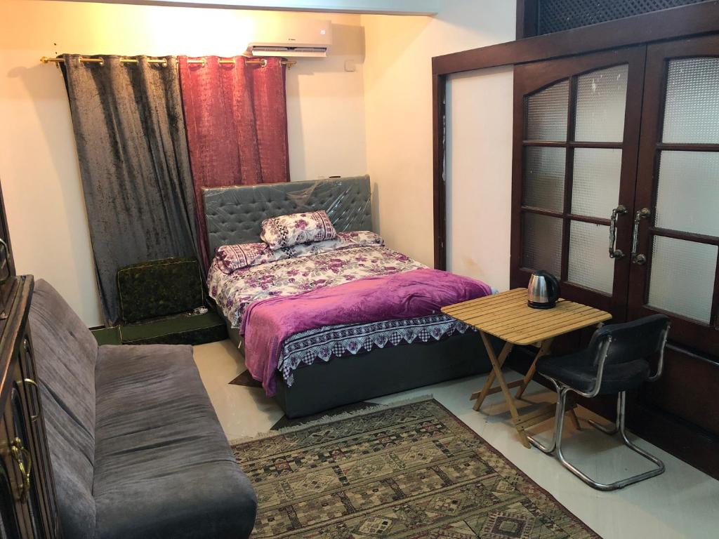 Manshīyat as SādātZagazig的卧室配有1张床和1张桌子及椅子