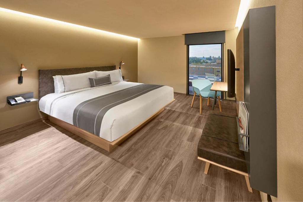 坦皮科City Express Plus by Marriott Tampico的酒店客房设有床和窗户。
