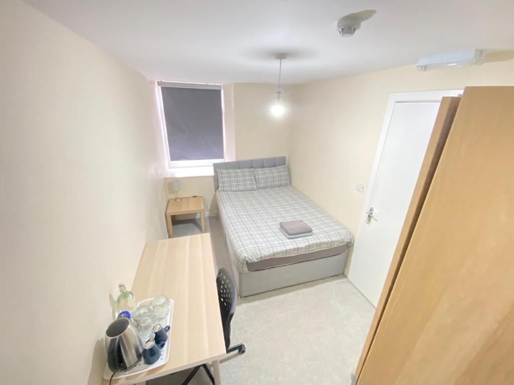 格拉斯哥Rangers GuestHouse的小房间设有一张小床和一张桌子