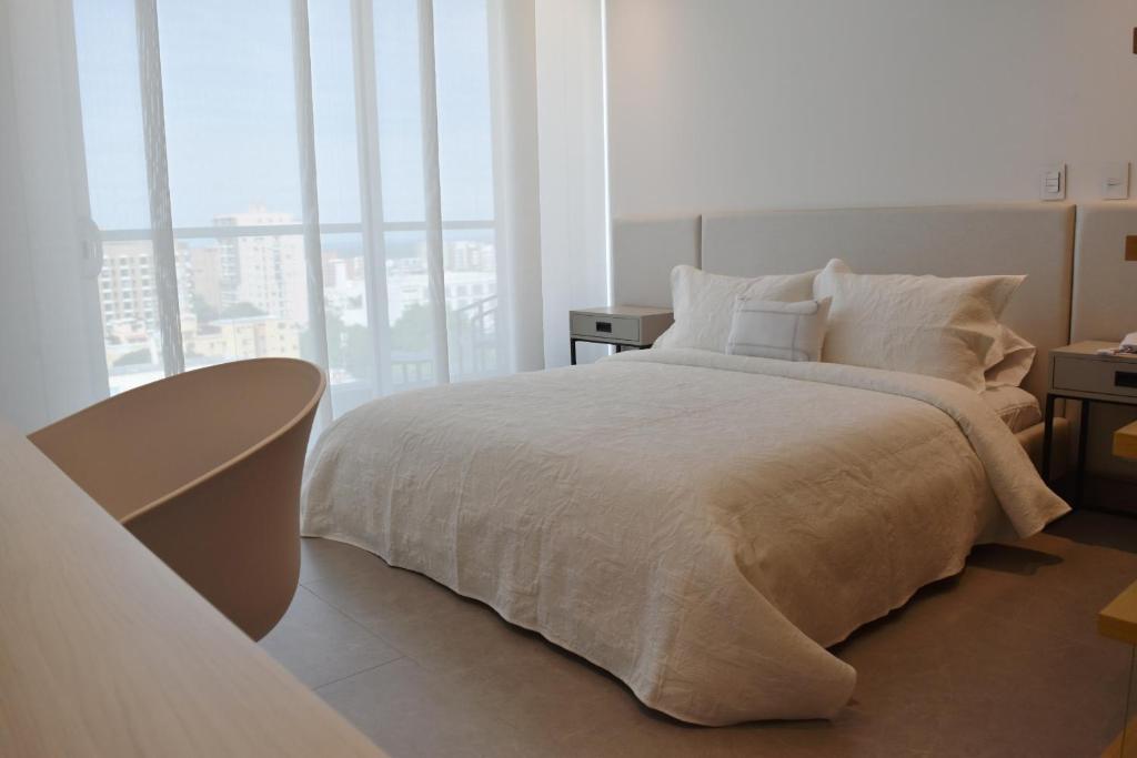 巴兰基亚Apartaestudio DISTRITO 90的一间卧室设有一张床和一个大窗户