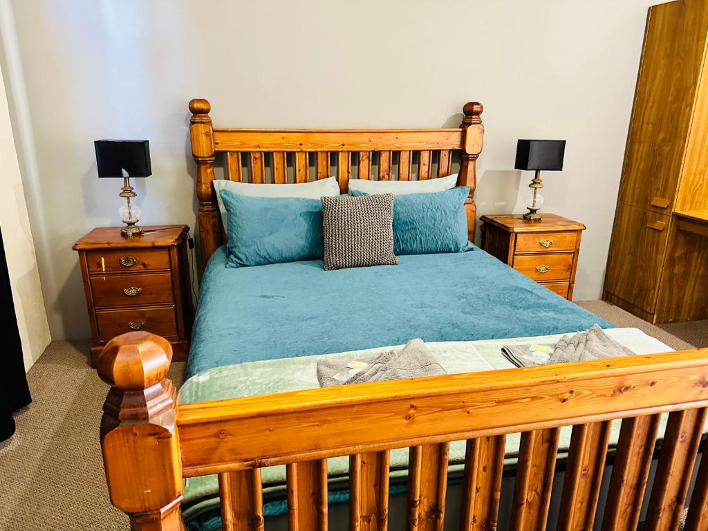 Quorn弗林德斯瑞格斯汽车旅馆 - 磨坊的一间卧室配有木床和2个床头柜