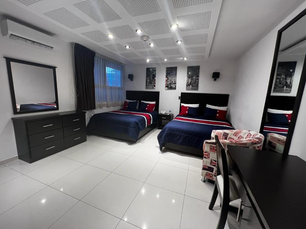 杜兰戈Gran Hotel Elizabeth的一间卧室配有两张床和电视。