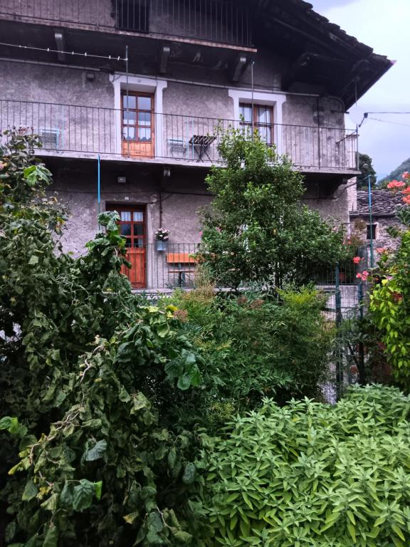 蓬圣马丁安蒂卡住宿加早餐旅馆的一座有红门和灌木丛的古老建筑