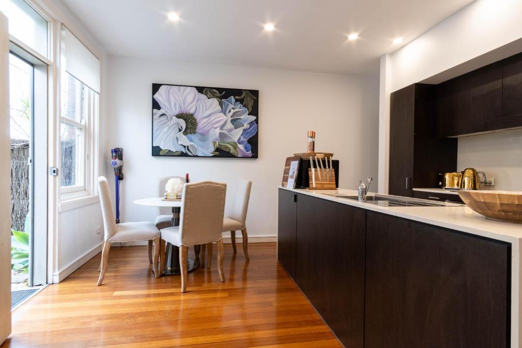 悉尼Eggie's Nest - Luxury City Apartment的厨房配有柜台和桌椅
