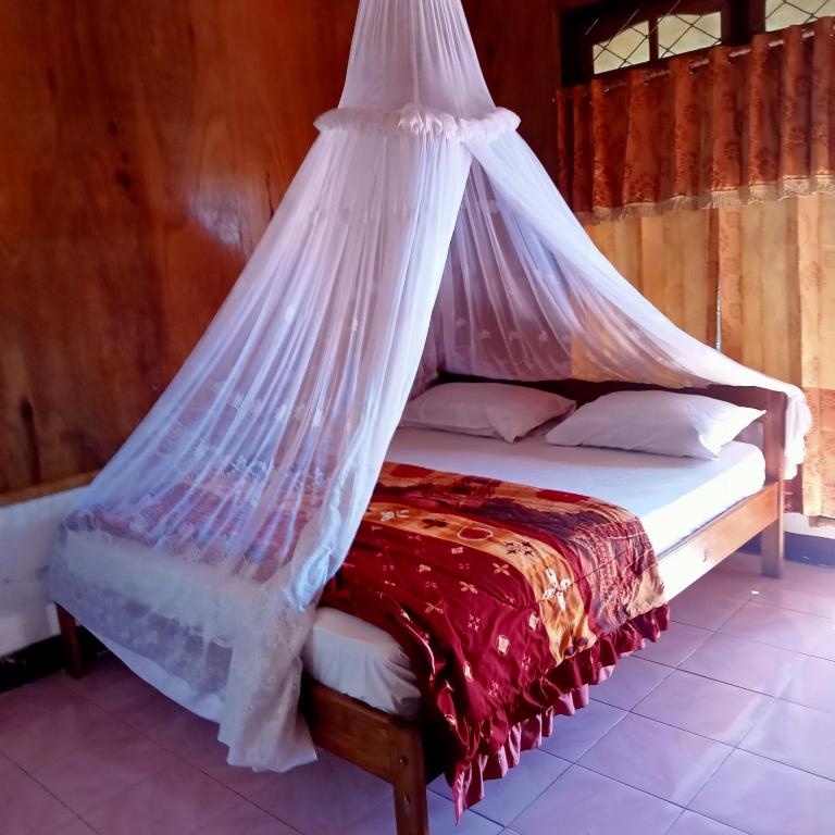 克里穆图WATUGANA BUNGALOW KELIMUTU的床上挂有蚊帐的床