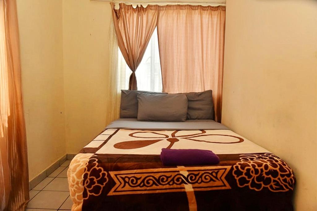 约翰内斯堡Asmara Hotel的窗户客房内的一张床位
