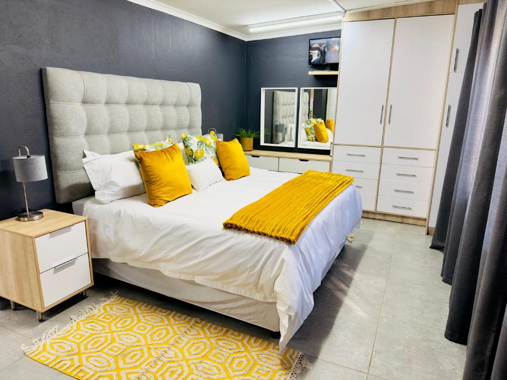 波罗瓜尼Lemon Ivy Guesthouse的一间卧室配有一张带黄色枕头的大床