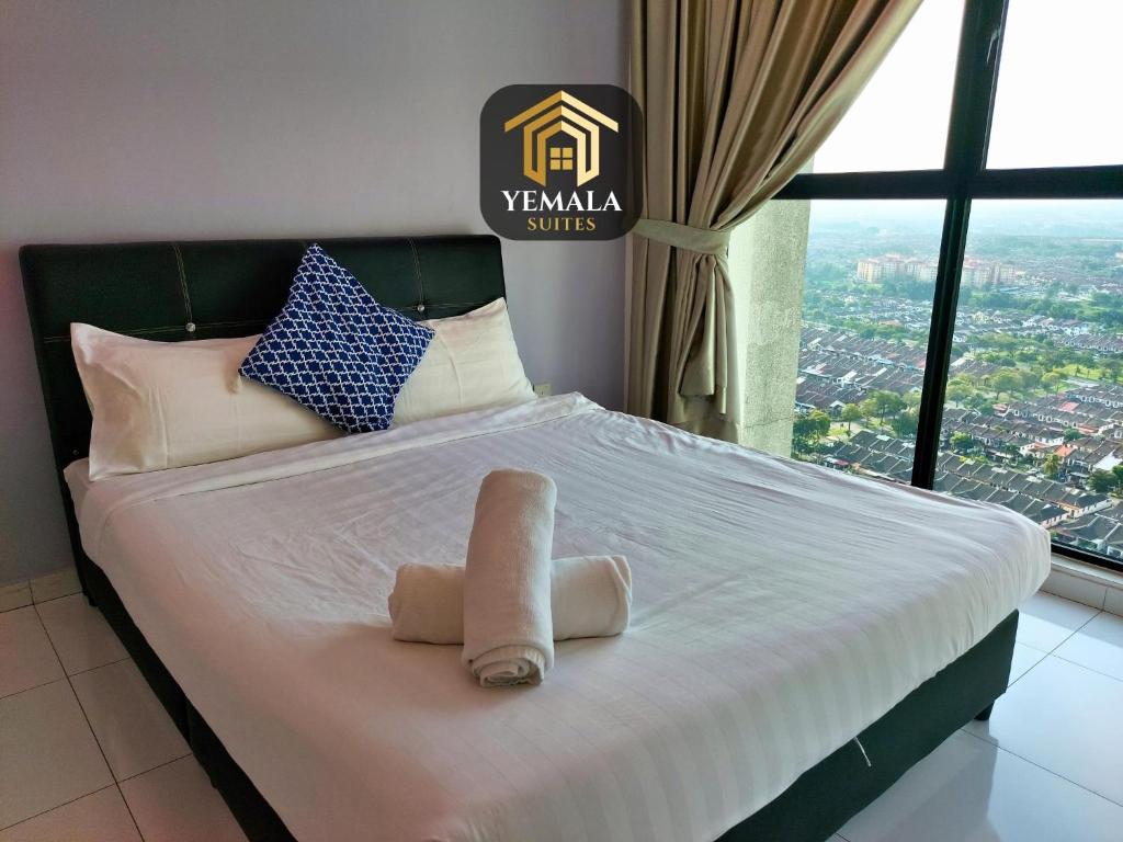 新山Yemala Suites at Skyloft - Johor的窗户间里一张带毛巾的床