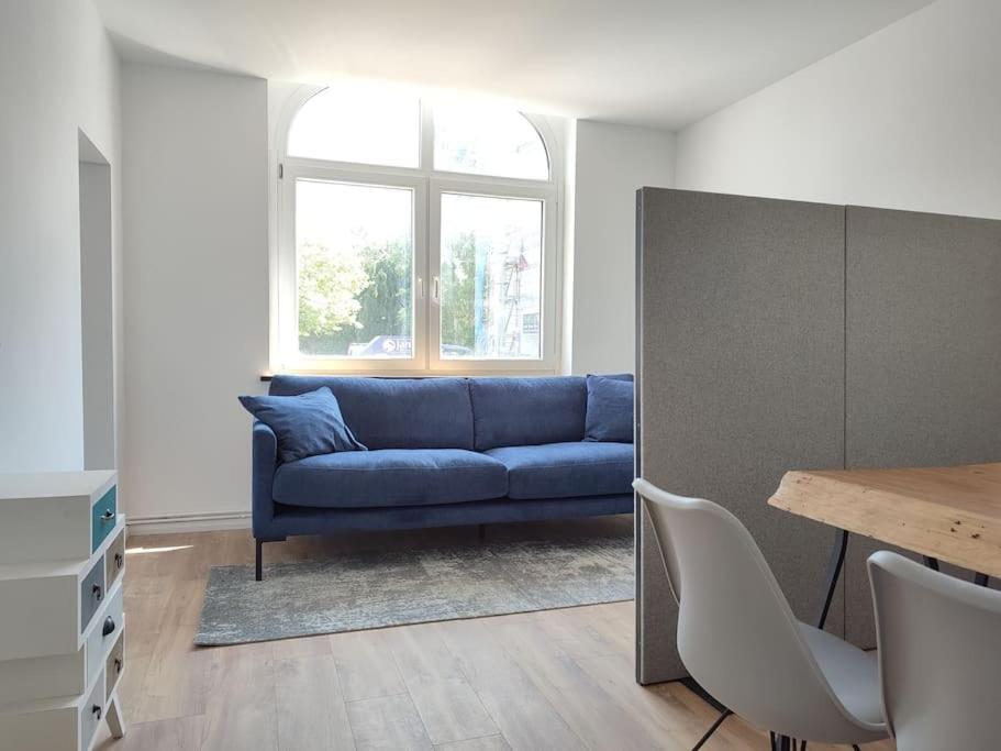 比勒费尔德'BRIGHT 201' Moderne, helle Wohnung in BI Zentrum, 400 m bis Lokschuppen, Smart-TV, WLAN的客厅配有蓝色的沙发和桌子