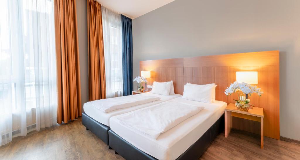 科隆PLAZA Premium Köln的一间卧室配有一张大床和木制床头板