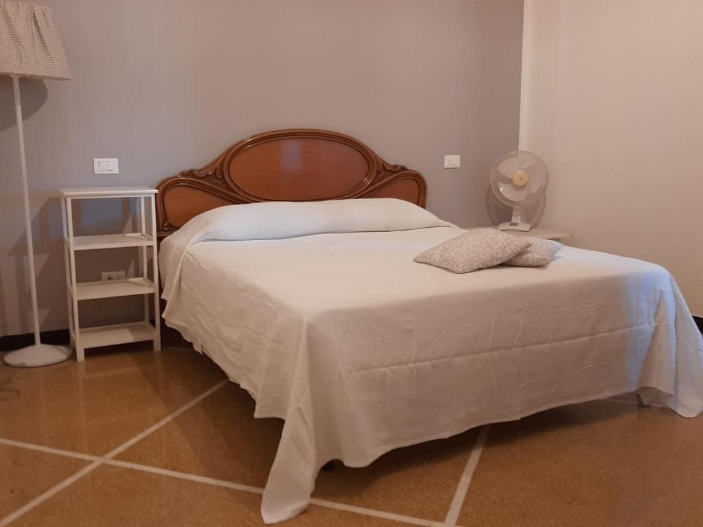 热那亚APPARTAMENTI IN GENOVA DALLO ZIO 150 mq的卧室配有一张床和一盏灯,铺有瓷砖地板。