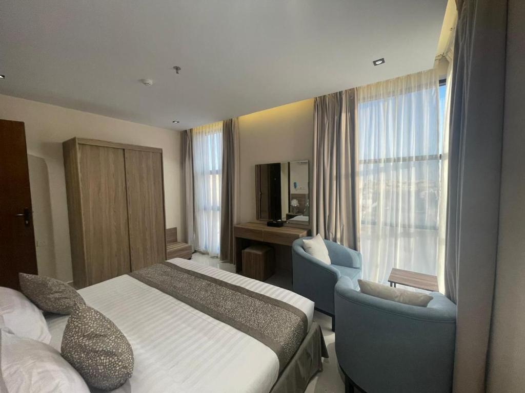 哈费尔巴廷HIGH VIEW HOTEL فندق عالية الاطلالة的酒店客房带一张床、椅子和窗户