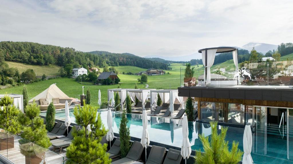 卡斯特尔罗托ABINEA Dolomiti Romantic SPA的一座带游泳池和度假村的酒店