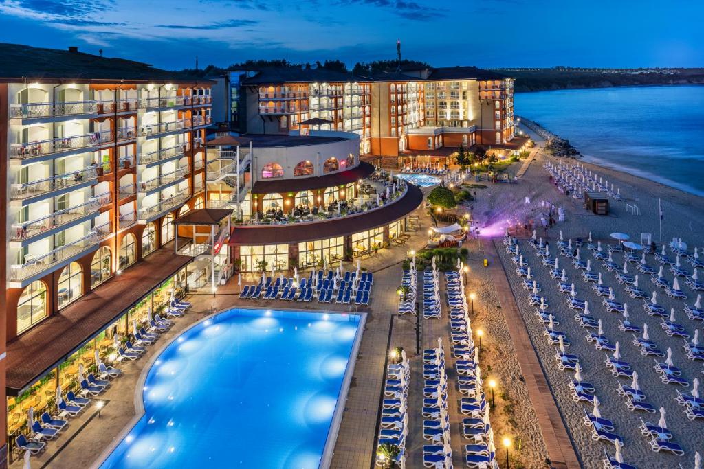 奥布佐尔Sol Luna Bay All Inclusive的夜间有游泳池和海滩的酒店