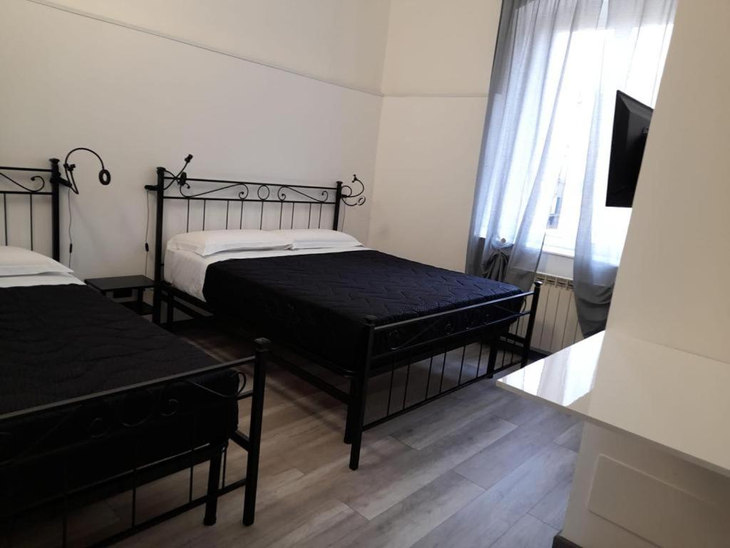 热那亚Affitta Camere La Turandot的一间卧室配有两张床和一台平面电视