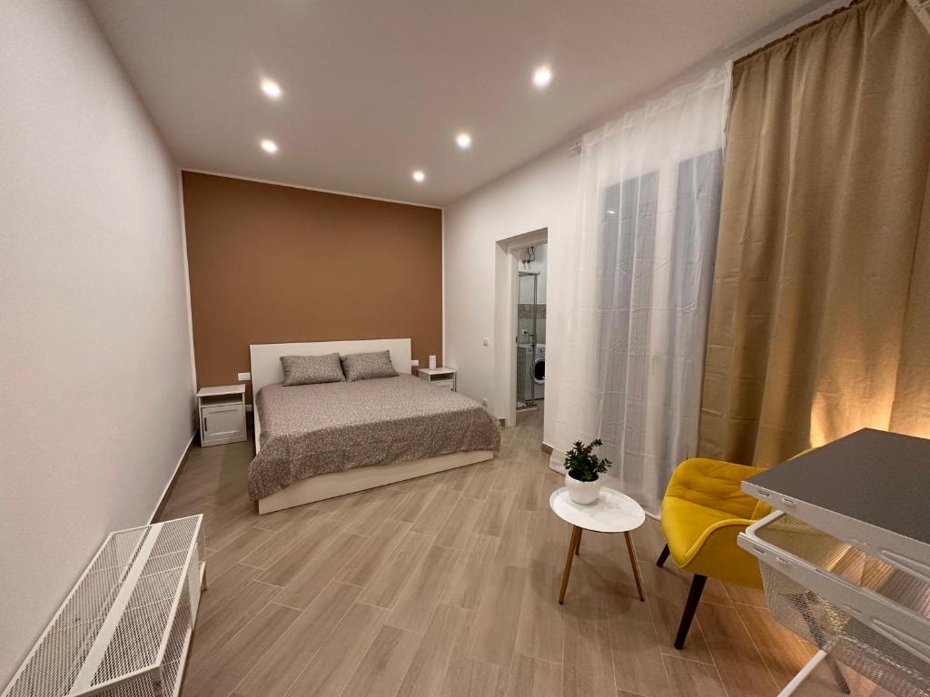 特拉帕尼Casa AnnaBella的一间卧室配有一张床和一张黄色椅子