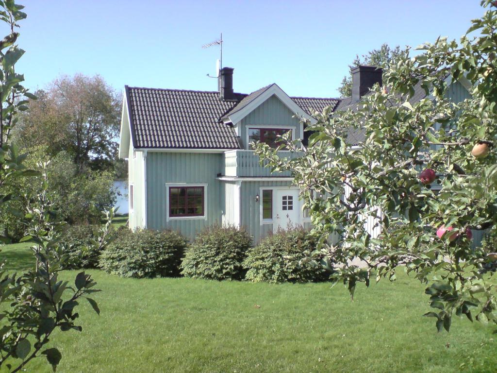 阿尔沃斯塔Fridhem gröna hus 14 pers och Fridhem röda hus 8 pers的一座带庭院的绿色房子