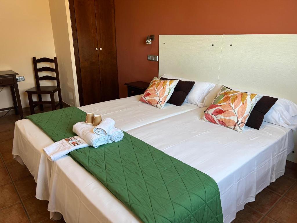 厄尔埃基多HOSTAL TREVELEZ的一间卧室配有两张带毛巾的床